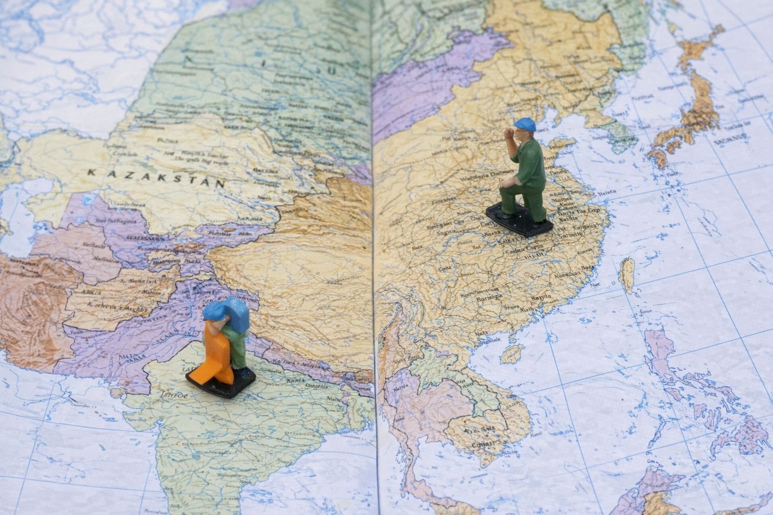 Miniaturfiguren auf einer Landkarte von Asien zur Illustration von Logistik.